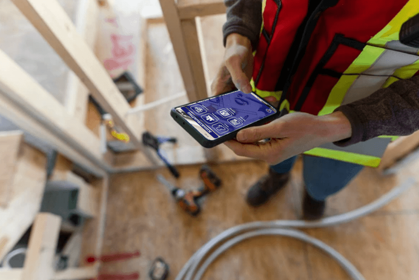 Mobile-on-site Konstrux Pro App construction worker holding plans